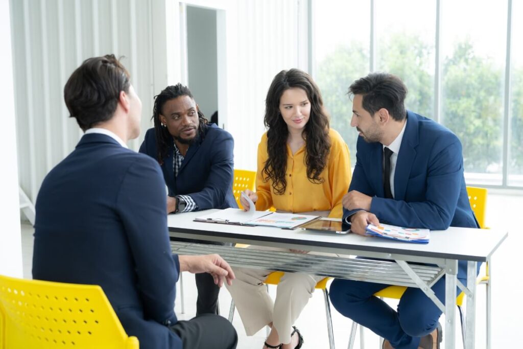 team meeting around table in glass office